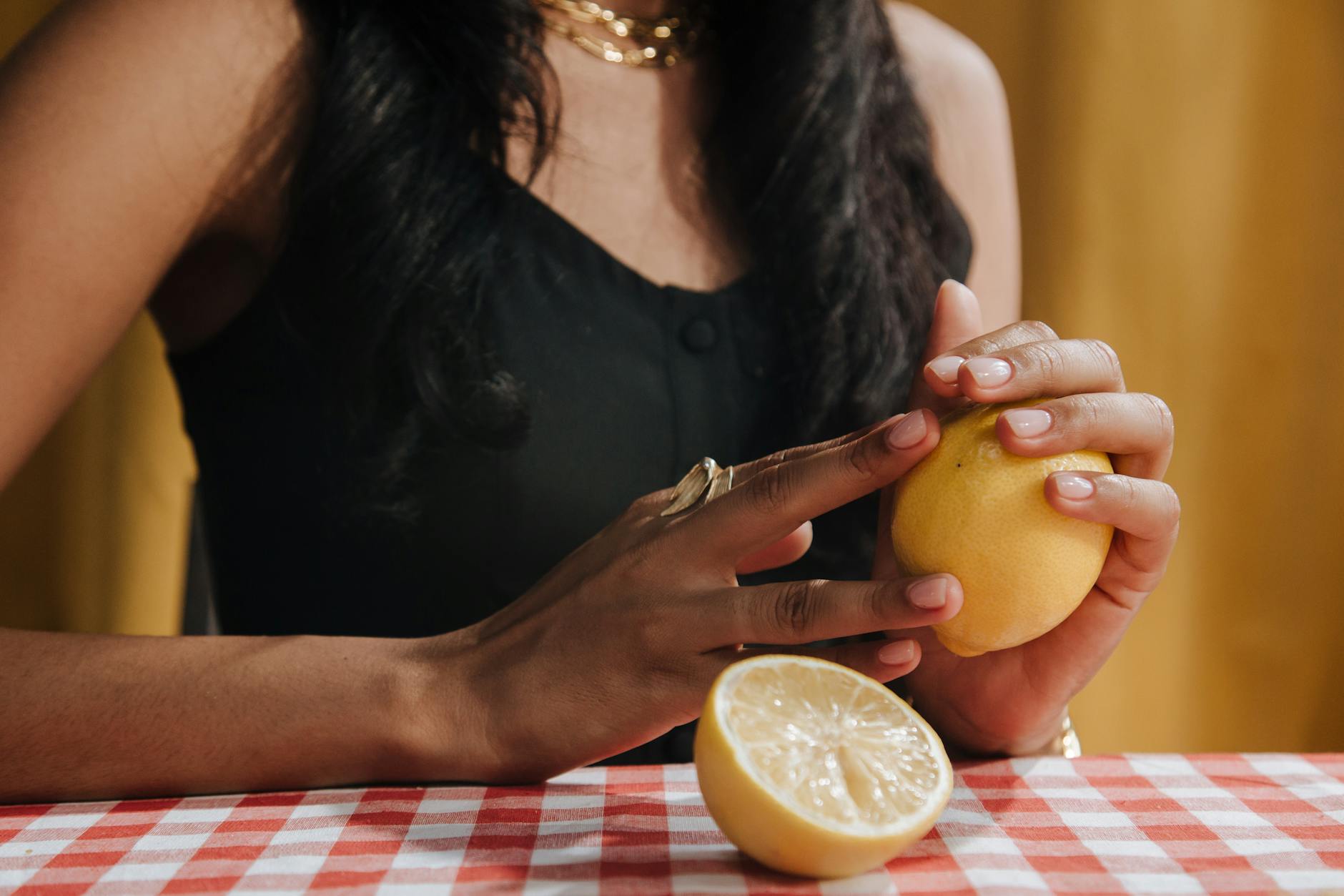 Close-up of a woman holding a fresh lemon, symbolizing natural approaches to sensation and pleasure