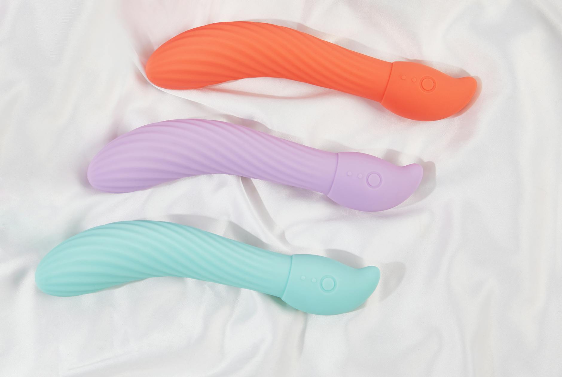 Vibrant collection of colorful clitoral vibrators arranged on a bright yellow surface, representing modern intimacy and playfulness