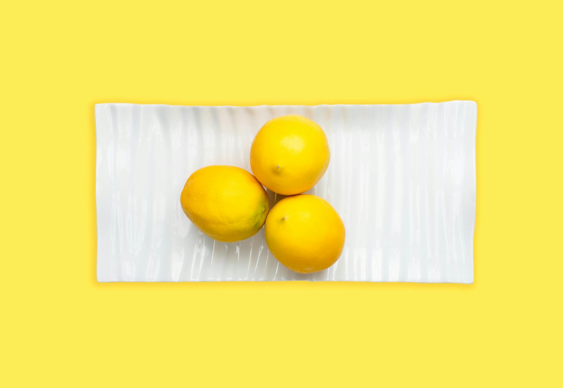 Two fresh lemons held in cupped hands on a brown surface, symbolizing care and sensitivity