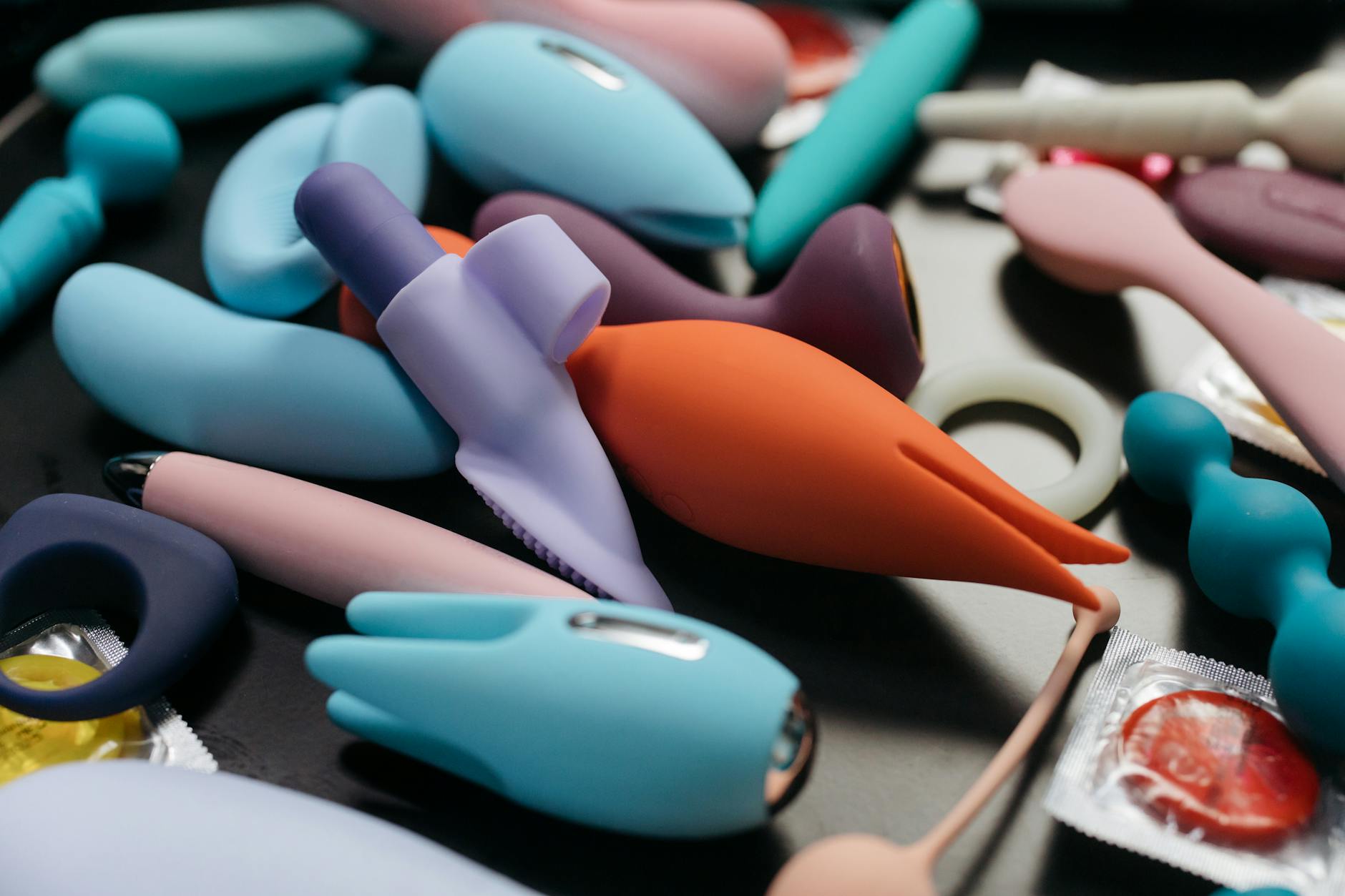 An array of vibrant clitoral vibrators and sex toys in a close-up view