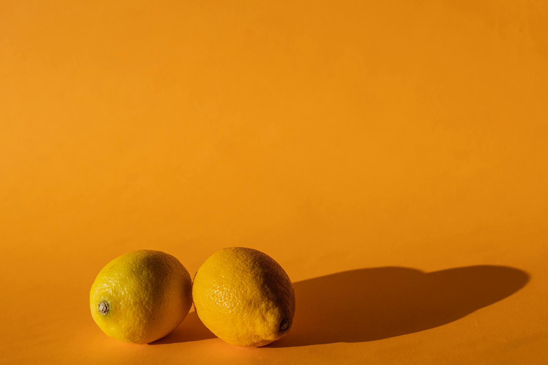 Bright vivid lemons on a yellow background in natural daylight